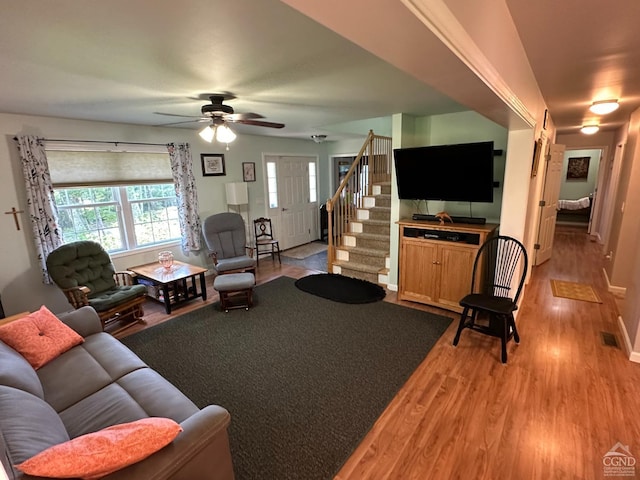 living room with ceiling fan and light hardwood / wood-style flooring