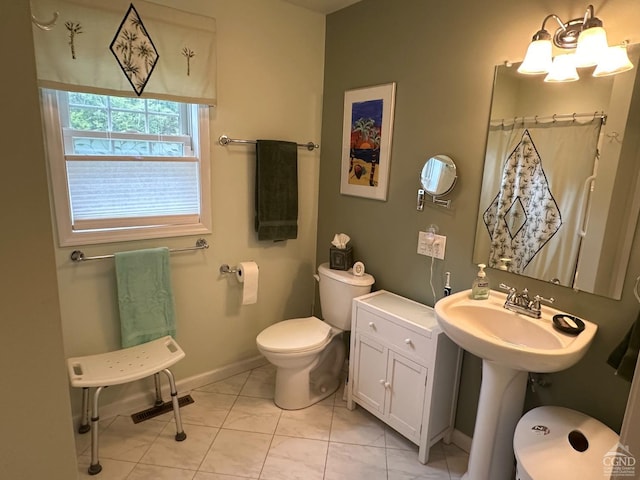 bathroom featuring tile patterned flooring, toilet, sink, and walk in shower