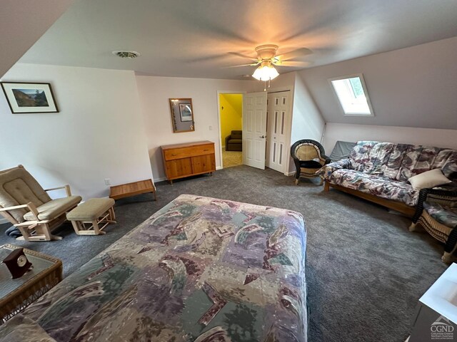 bedroom featuring a closet, a skylight, dark carpet, and ceiling fan