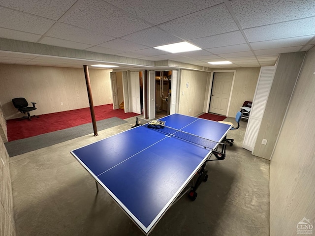 playroom featuring a paneled ceiling and concrete floors