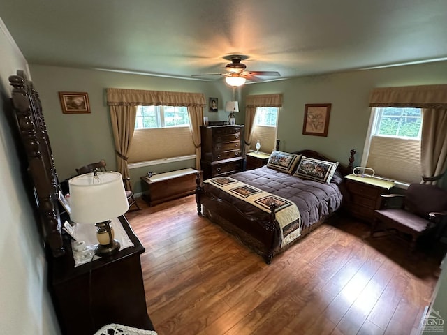 bedroom with ceiling fan, light hardwood / wood-style flooring, and multiple windows