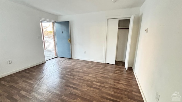 unfurnished bedroom featuring dark wood-type flooring, a closet, and baseboards