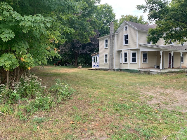 view of side of property with a yard and a porch