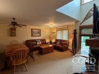 living room featuring ceiling fan and light colored carpet