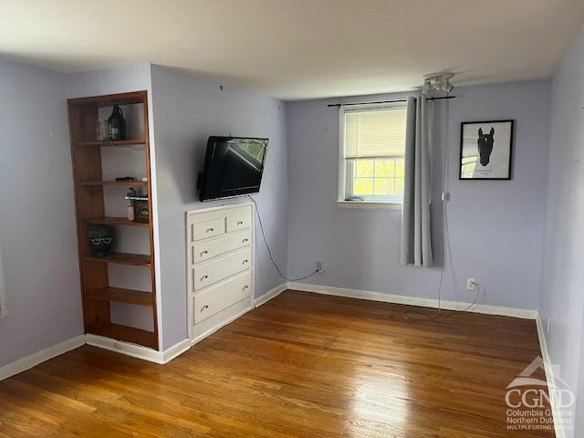 unfurnished bedroom featuring baseboards and wood finished floors