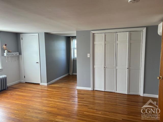 unfurnished bedroom with baseboards and wood finished floors