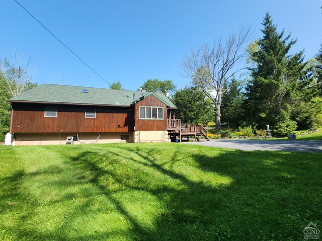 rear view of property with a lawn and a deck