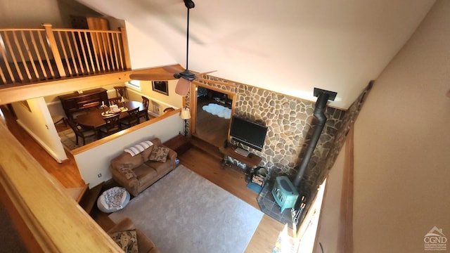 living room featuring hardwood / wood-style floors, a wood stove, and ceiling fan