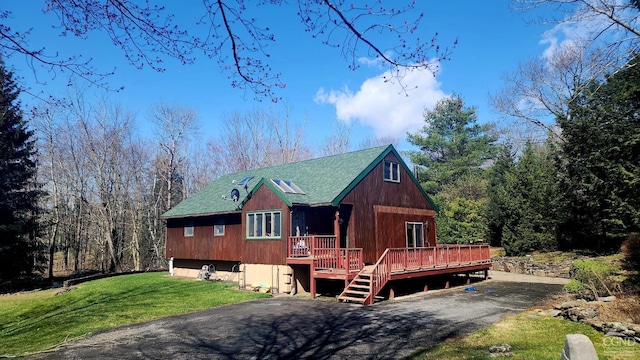 view of front facade featuring a wooden deck and a front yard