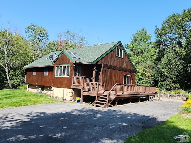 view of front of property with a front yard and a deck