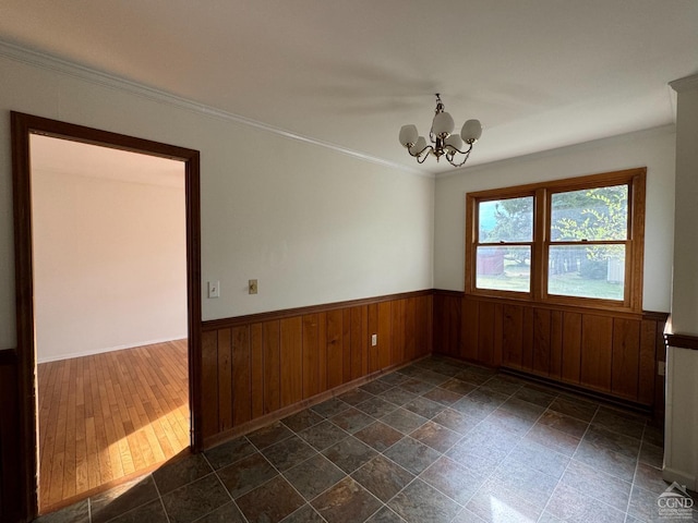 unfurnished room with wood walls, dark hardwood / wood-style flooring, ornamental molding, and a chandelier