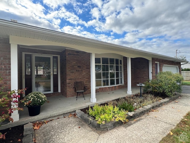 property entrance with covered porch and a garage