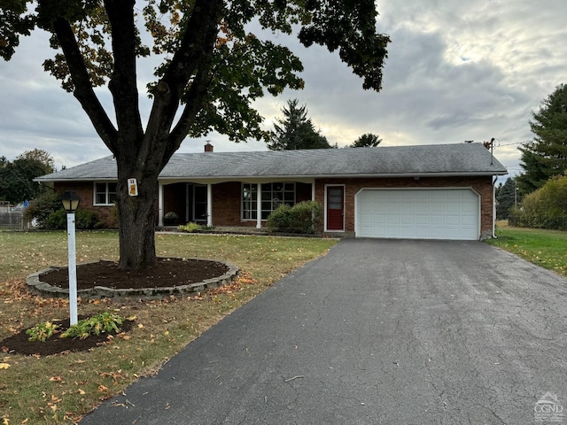 ranch-style home with a garage and a front lawn