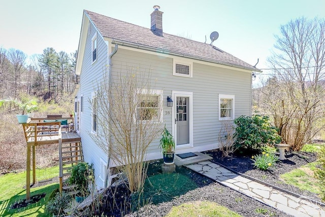 rear view of house with stairs, a chimney, and a deck
