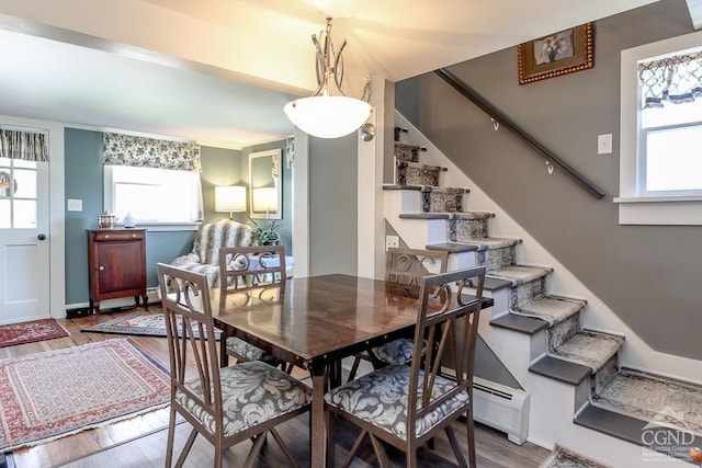 dining area featuring plenty of natural light, stairs, and wood finished floors