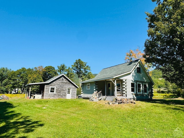 rear view of house featuring a lawn and log siding