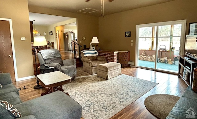 living room with baseboards, baseboard heating, and wood finished floors