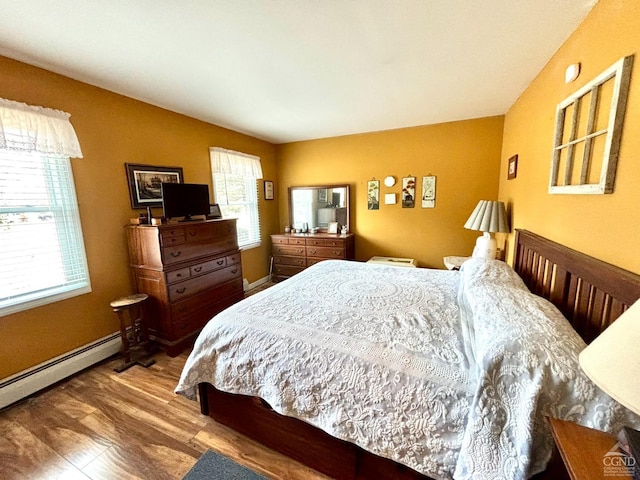 bedroom featuring baseboards, multiple windows, and wood finished floors