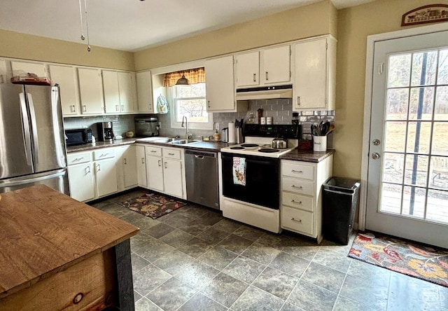 kitchen with under cabinet range hood, appliances with stainless steel finishes, tasteful backsplash, and a sink