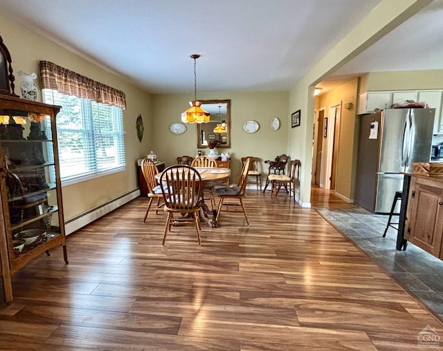 dining space with dark wood-type flooring and baseboard heating