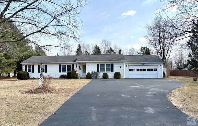 single story home featuring aphalt driveway, a garage, a chimney, and fence