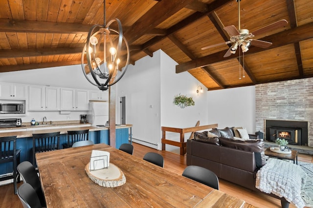 dining space with beam ceiling, wood ceiling, baseboard heating, and light hardwood / wood-style flooring