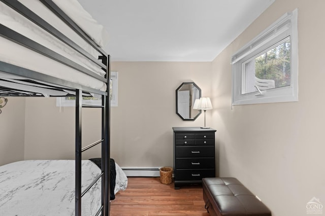 bedroom featuring hardwood / wood-style floors and a baseboard radiator