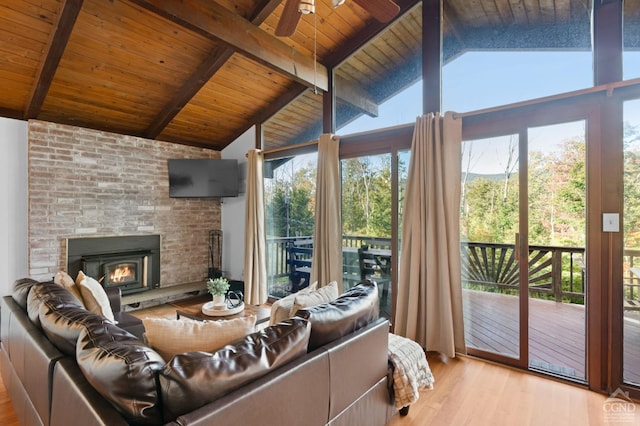 living room featuring wood ceiling, a large fireplace, ceiling fan, beam ceiling, and light hardwood / wood-style floors