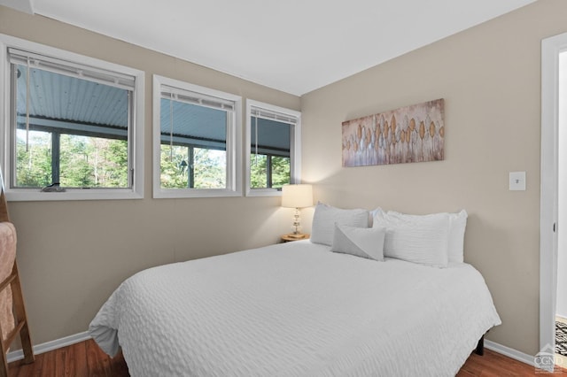 bedroom with dark hardwood / wood-style flooring