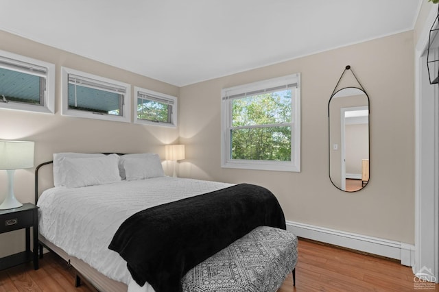 bedroom featuring a baseboard radiator and wood-type flooring