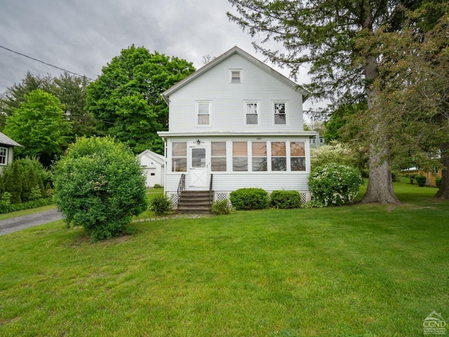 rear view of property with a sunroom and a yard