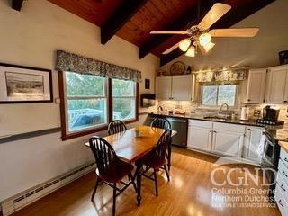 dining room with ceiling fan, sink, baseboard heating, lofted ceiling with beams, and wood ceiling