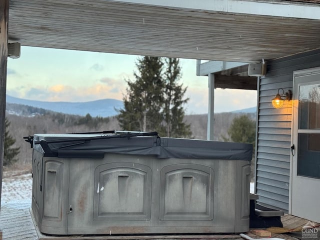 view of patio / terrace with a mountain view and a hot tub