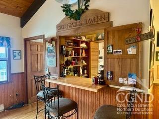 bar with hardwood / wood-style floors, vaulted ceiling with beams, wooden walls, and wood ceiling