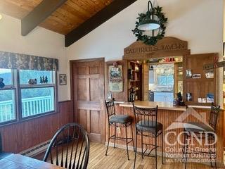 bar with hardwood / wood-style flooring, vaulted ceiling with beams, wood ceiling, and wooden walls