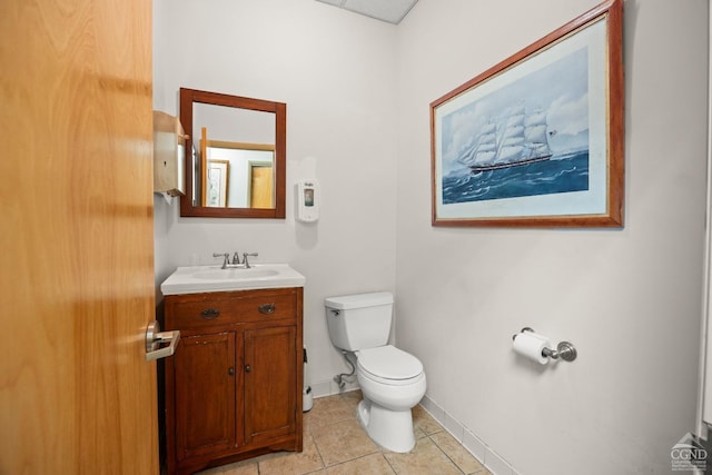 bathroom featuring toilet, vanity, tile patterned floors, and baseboards