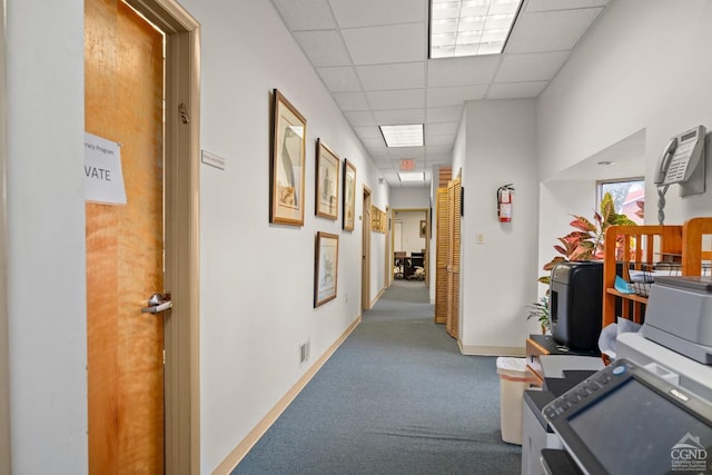 hallway featuring baseboards, a paneled ceiling, visible vents, and carpet floors