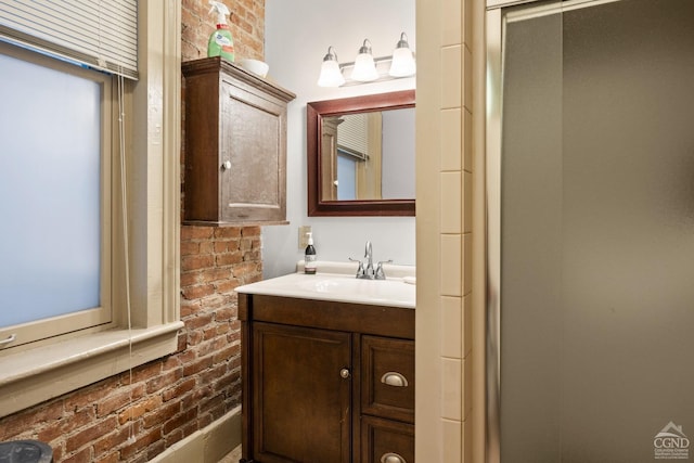 bathroom featuring brick wall and vanity