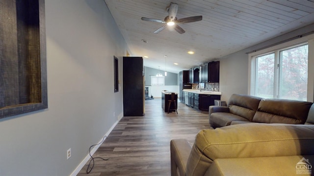 living room with ceiling fan, wood-type flooring, and lofted ceiling