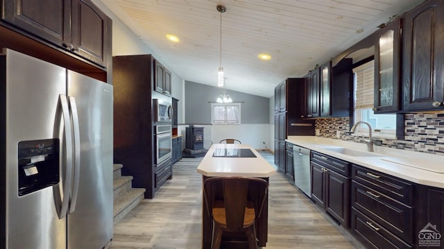 kitchen featuring sink, light wood-type flooring, decorative light fixtures, and appliances with stainless steel finishes