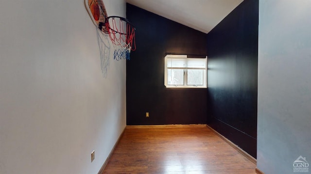 unfurnished room featuring wood-type flooring and lofted ceiling