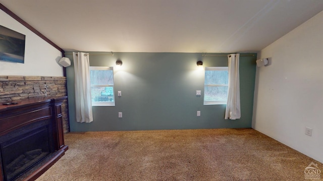 carpeted living room featuring a stone fireplace