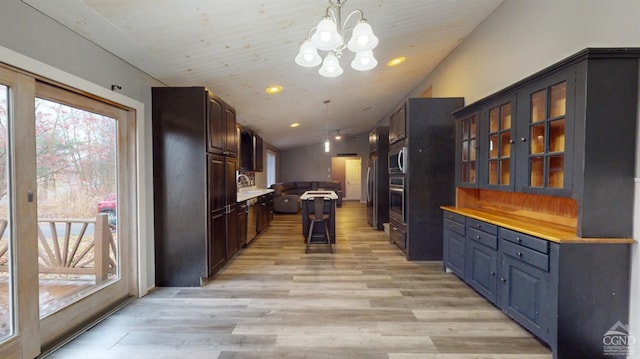 kitchen featuring light hardwood / wood-style flooring, pendant lighting, lofted ceiling, and appliances with stainless steel finishes