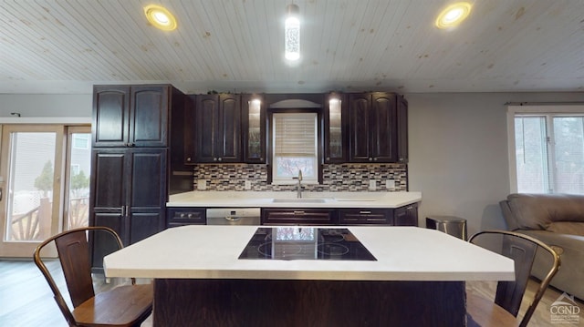 kitchen with black electric stovetop, a center island, sink, and light hardwood / wood-style flooring