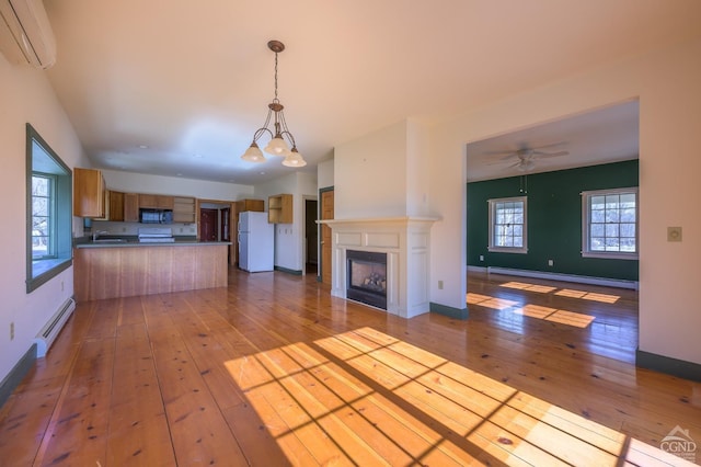 kitchen featuring light hardwood / wood-style flooring, white refrigerator, baseboard heating, a wall unit AC, and pendant lighting