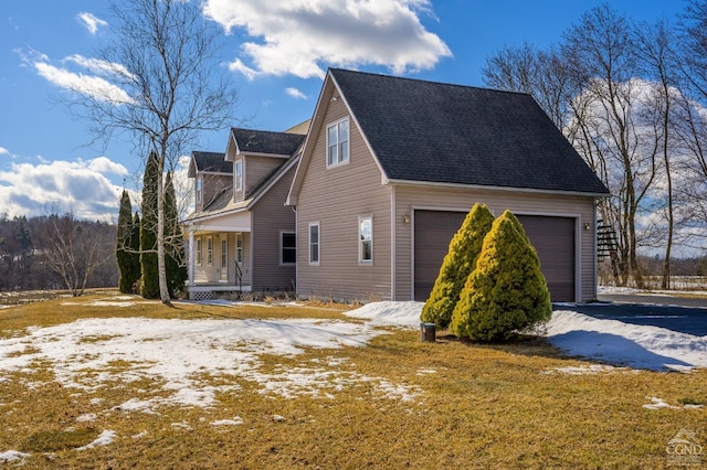 view of snowy exterior with a garage and a porch
