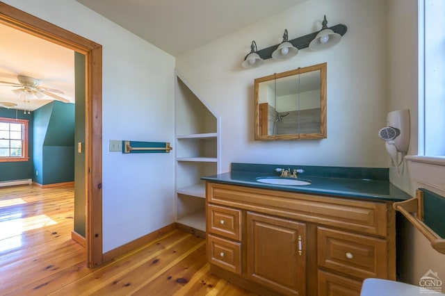 bathroom with vanity, hardwood / wood-style floors, ceiling fan, and baseboard heating