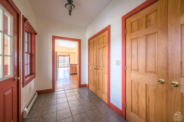 hall featuring baseboard heating and dark tile patterned floors