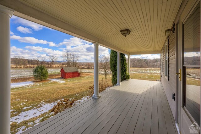 wooden deck with a storage unit and a rural view
