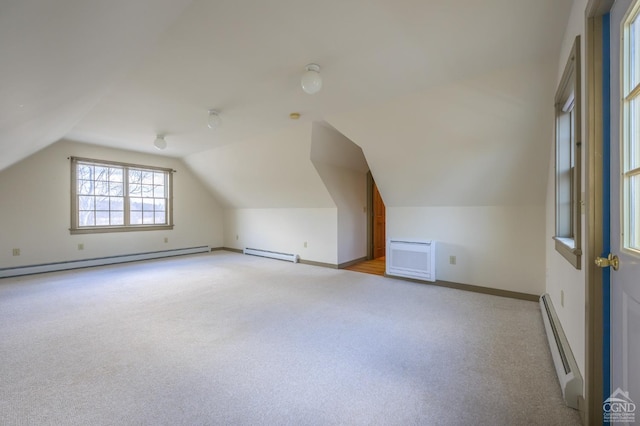 bonus room featuring vaulted ceiling, a baseboard heating unit, and light carpet